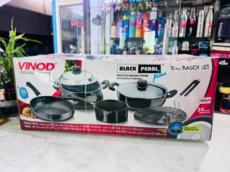 Vinod Black Pearl 5-piece rasoi set on the counter, shelves of bottles behind
